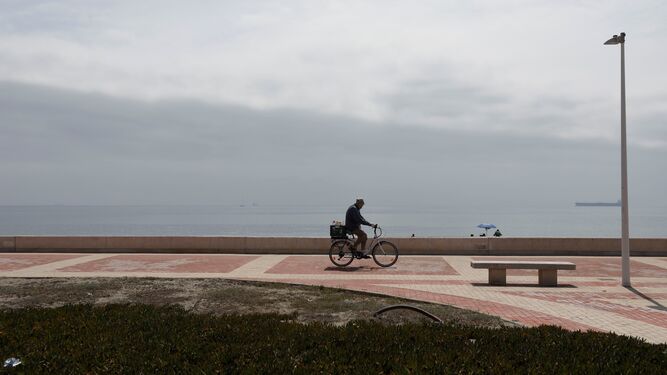 Un ciclista en el paseo de la playa de Levante de La Línea.
