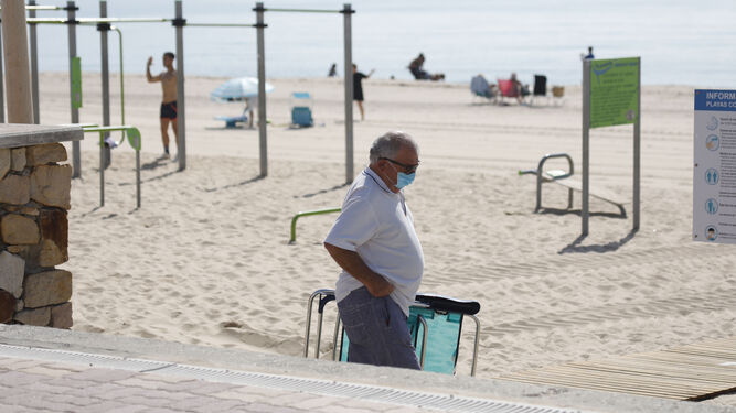 Un hombre ataviado con su mascarilla accede a la playa de Getares, en Algeciras.