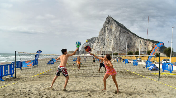 Cuatro personas juegan al pádel en la playa de Levante de La Línea.