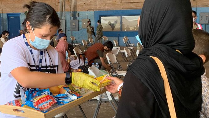 Una mujer afgana recibe suministros en la Base de Rota.