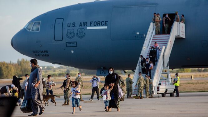 Familias afganas salen de un avión que aterrizó este lunes a primera hora en la Base.