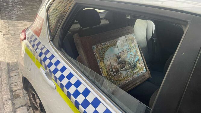 El azulejo de la Virgen de la Luz, en un coche patrulla.