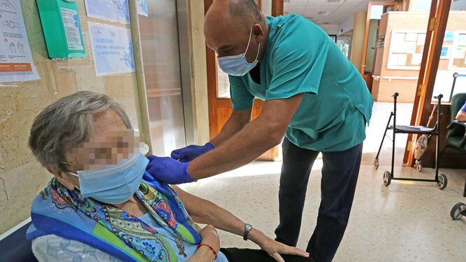 Una mujer siendo vacunada de la tercera dosis en el hospital San Juan Grande