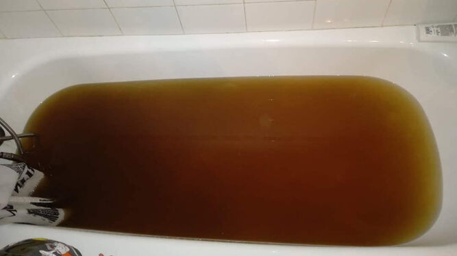 Una bañera llena de agua marrón, en Jimena.