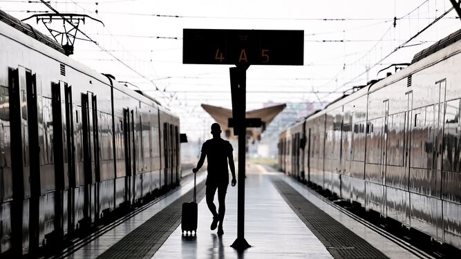 Un joven camina por el andén de la estación