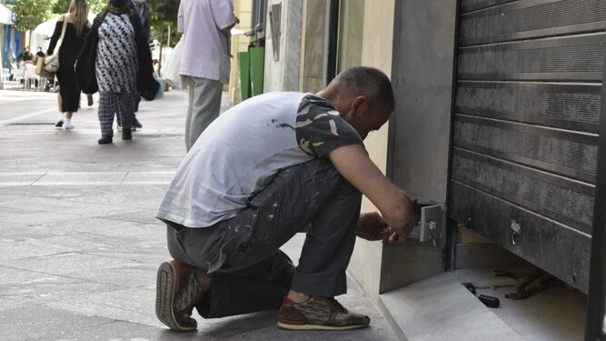 Un electricista repara una puerta mecánica en el centro de Algeciras, este miércoles.