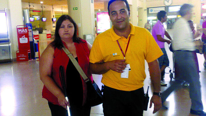 Uno de los asistentes acompaña a una viajera en la terminal de salidas del aeropuerto de Málaga.