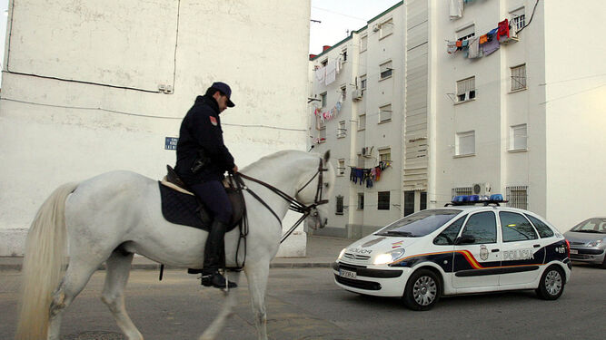 La Policía Nacional, a caballo y en coche durante una de las jornadas de vigilancia en la barriada de Jsé Antonio, en el año 2005.