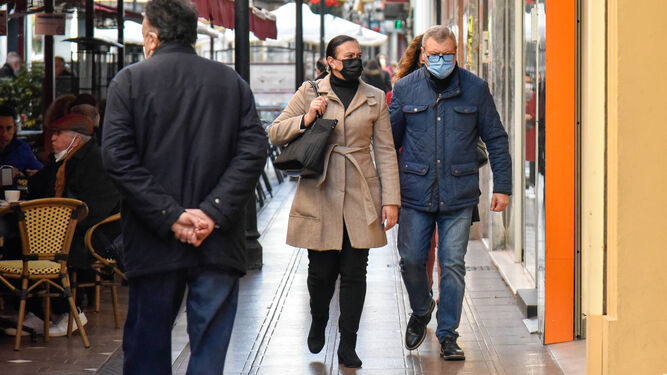 Dos personas con mascarilla caminan por la Calle Real de La Línea.