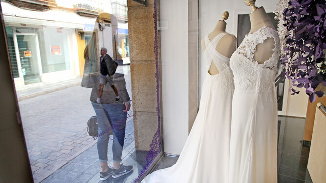 Una mujer mira un escaparate con vestidos de novia