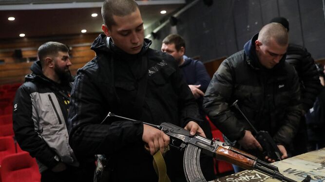 Civiles ucranianos reciben instrucción sobre el manejo de armas dentro de un cine en Leópolis, al oeste del país.