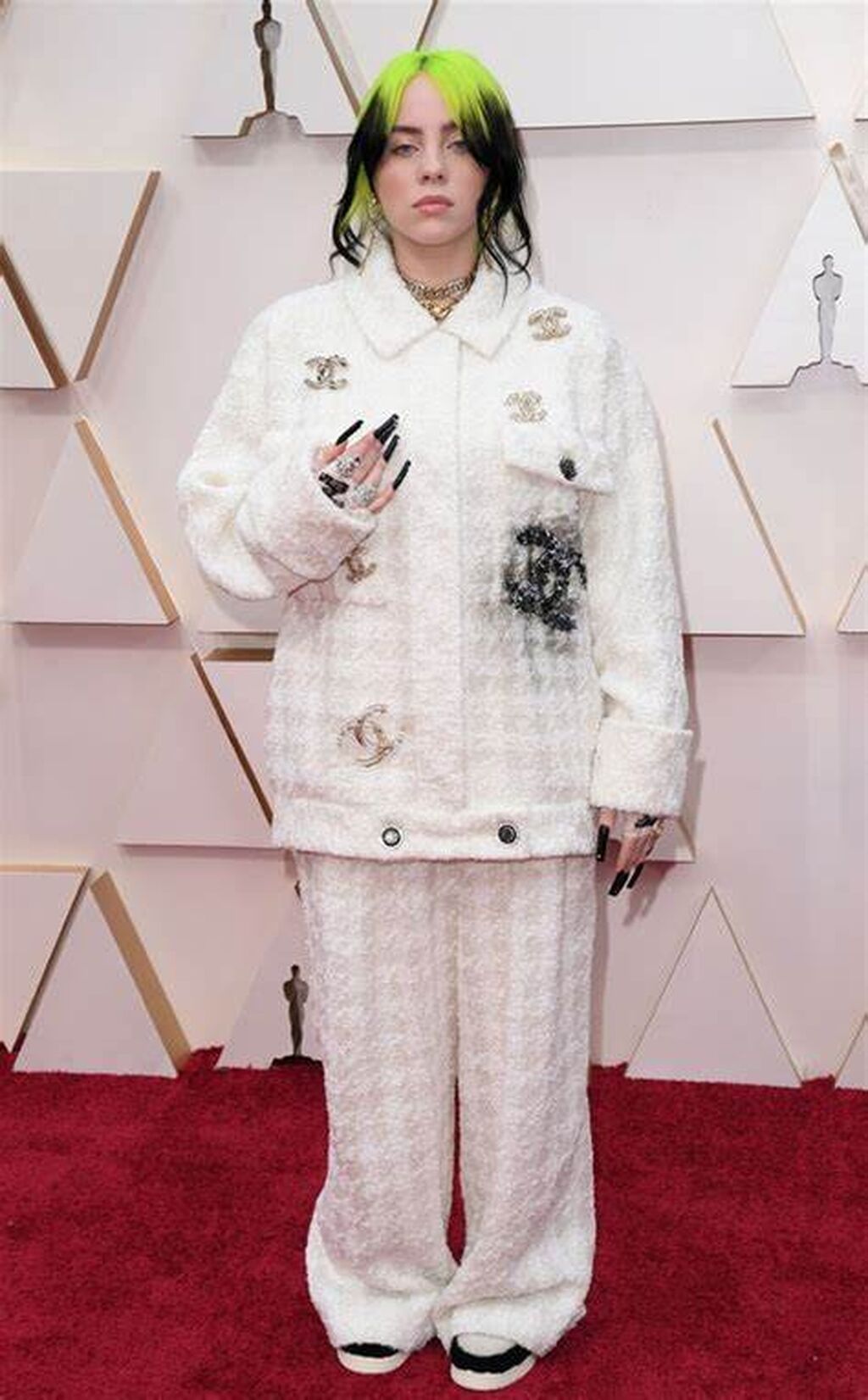 Billie Eilish llev&oacute; un conjunto de chaqueta y pantal&oacute;n blanco con detalles plateados de Chanel a la gala de 2020. Hasta ah&iacute; bien si no fuera porque le ven&iacute;a grand&iacute;simo. Las ra&iacute;ces verdes de su pelo y la manicura indefinible acabaron de estropear el estilismo.