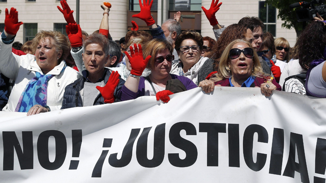 Una manifestación en la que varias personas exhiben manos rojas, símbolo contra las agresiones sexistas.