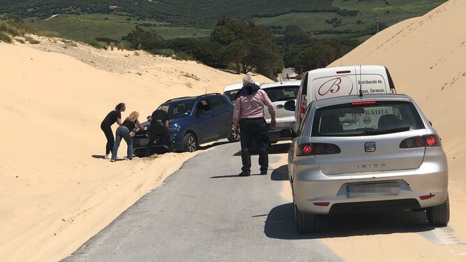 Tres personas empujan un coche atascado en la arena, este lunes.