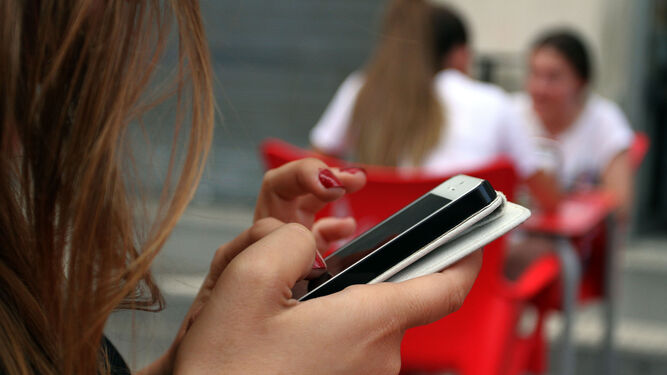 Una joven usando el móvil.