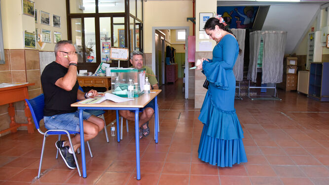 Una mujer vestida de flamenca se dispone a votar en Algeciras.