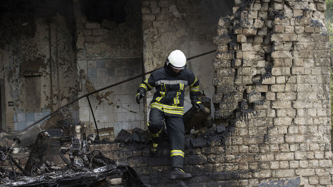 Bomberos trabajan para extinguir un incendio en un taller de calefactores atacado por artillería rusa en Jarkov.