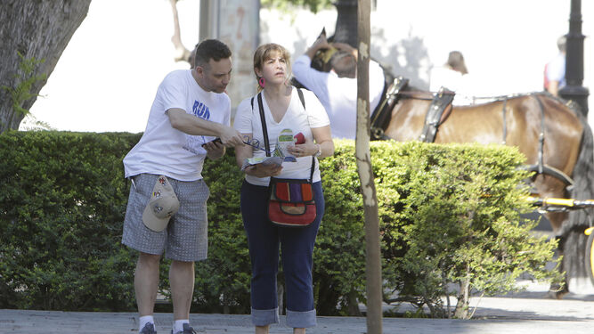 Dos turistas consultan un mapa en Sevilla.