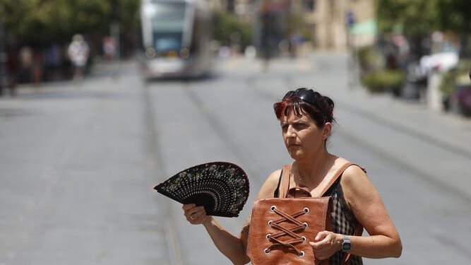 Una mujer trata de aliviarse del calor en Sevilla.
