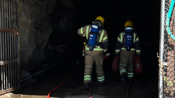 Dos bomberos acceden al túnel.