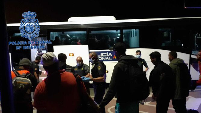Inmigrantes que desembarcaron en la playa de Camposoto, en el momento de ser trasladados en el autobús de la Policía.
