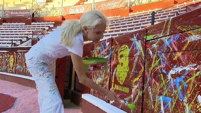 La artista alemana Uta Geub pintando en las tablas del ruedo de la Plaza de Toros de Sanlúcar.