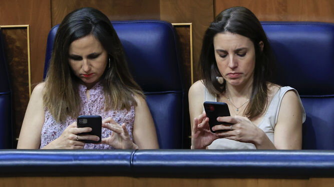La ministra de Derechos Sociales, Ione Belarra, y la de Igualdad, Irene Montero, consultan sus móviles en el Congreso