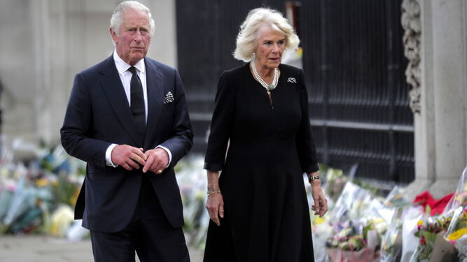 El rey Carlos III y Camilla, reina consorte, observan el homenaje floral ante el Palacio de Buckingham.