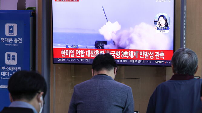 Varias personas observan el lanzamiento en una pantalla de televisión en Seúl.