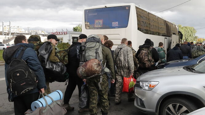 Un grupo de rusos se dispone a coger un autobús ante una oficina de reclutamiento en San Petersburgo.