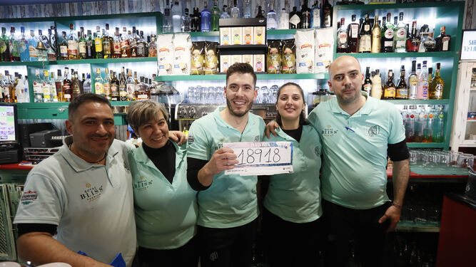 Miembros del personal de la cafetería Calusa posan con el número agraciado con el tercer premio del sorteo de El Niño.