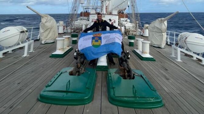 Daniel Yedra, con la bandera de La Línea, a bordo de Elcano