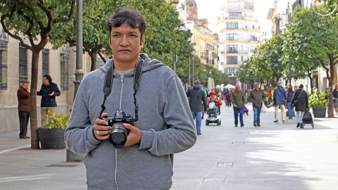 Abdullah Sadaqat, en la calle Larga, con el equipo donado por la Agrupación Fotográfica San Dionisio.