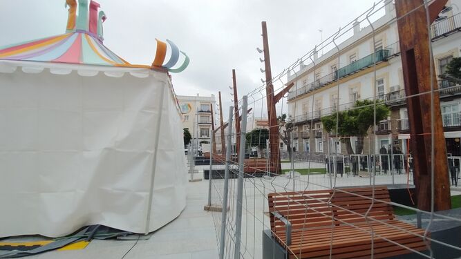 Vallas de obra colocadas tras las carpas para proteger las zonas del mobiliario urbano de la plaza del Rey.