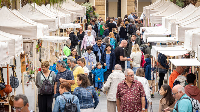 Turistas transitan por puestos artesanales instalados en la plaza de San Juan de Dios  de Cádiz.