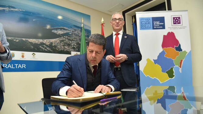 El ministro principal de Gibraltar, Fabian Picardo, firma en el libro de visitas de la Mancomunidad junto a Juan Lozano.