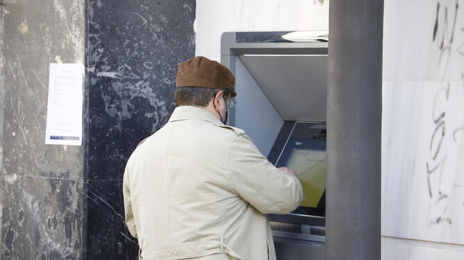 Un hombre saca dinero de un cajero  automático