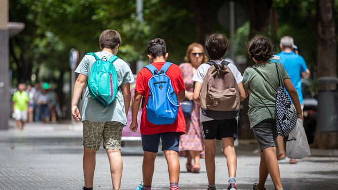 Cuatro menores caminan con sus mochilas, tras salir de la escuela