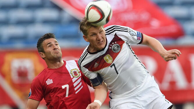 Lee  Casciaro pugna por un balón con Schweinsteiger en un partido contra Alemania.