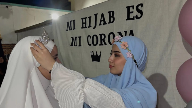 Una chica “corona” a otra que ha decidido cubrir su cabello con el hiyab.