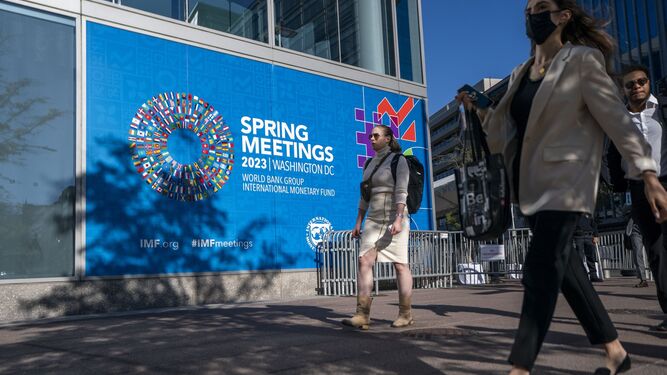 Gente camina fuera del edificio HQ2 del Fondo Monetario Internacional (FMI) durante las Reuniones de Primavera de 2023 del FMI y el Banco Mundial en Washington.