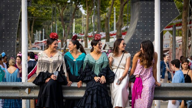 Unas jóvenes disfrutan junto a la portada de la Feria de El Puerto, en una jornada de encuentro con amistades y personas llegadas de toda la Bahía.