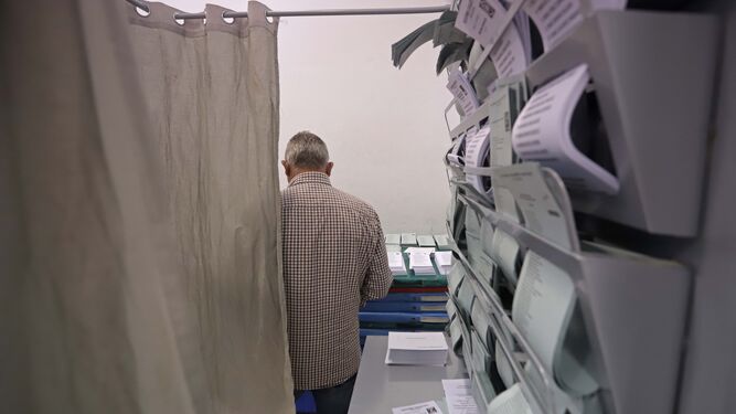 Un hombre busca entre las papeletas de un colegio electoral, en 2019.