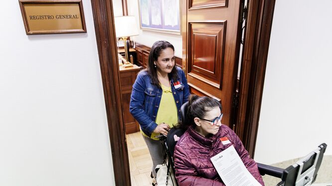 Una persona afectada de ELA sale tras registrar la petición de que se desbloquee la tramitación de la Ley ELA en el Congreso.