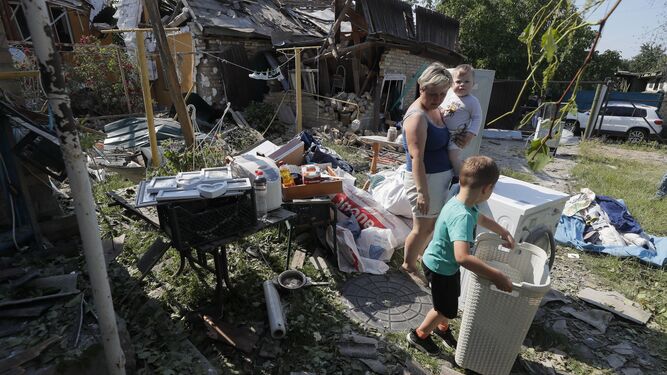Residentes ucranianos intentan rescatar sus pertenencias tras un ataque cerca de Kiev.
