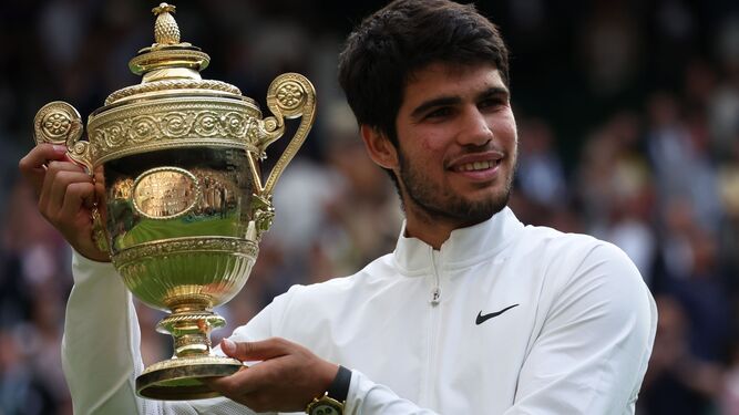Carlos Alcaraz muestra orgulloso su trofeo en Wimbledon.
