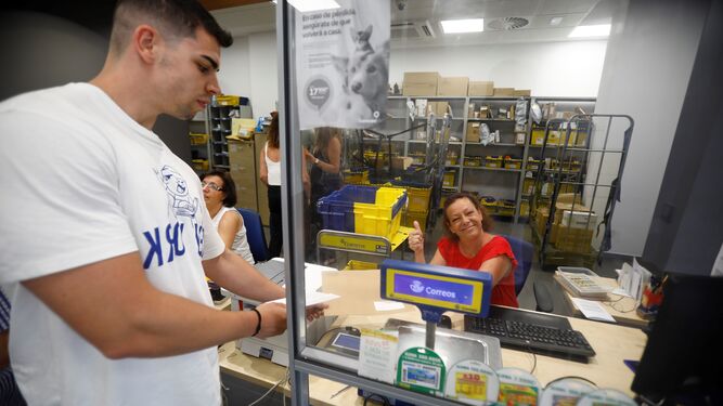 Un elector hace el trámite del voto por correo en una oficina postal de Córdoba.