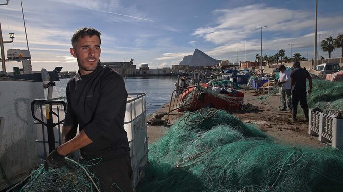 Jonathan Sánchez limpia las redes en el Puerto de La Atunara.
