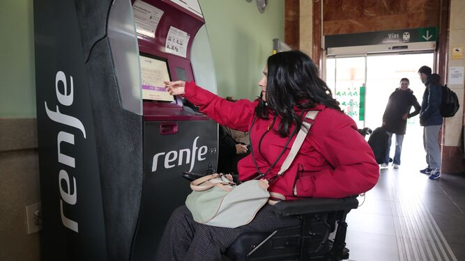 Una persona con discapacidad compra un billete de Renfe.