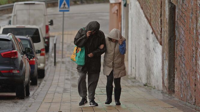 Dos personas se protegen de la lluvia este viernes en el Campo de Gibraltar.